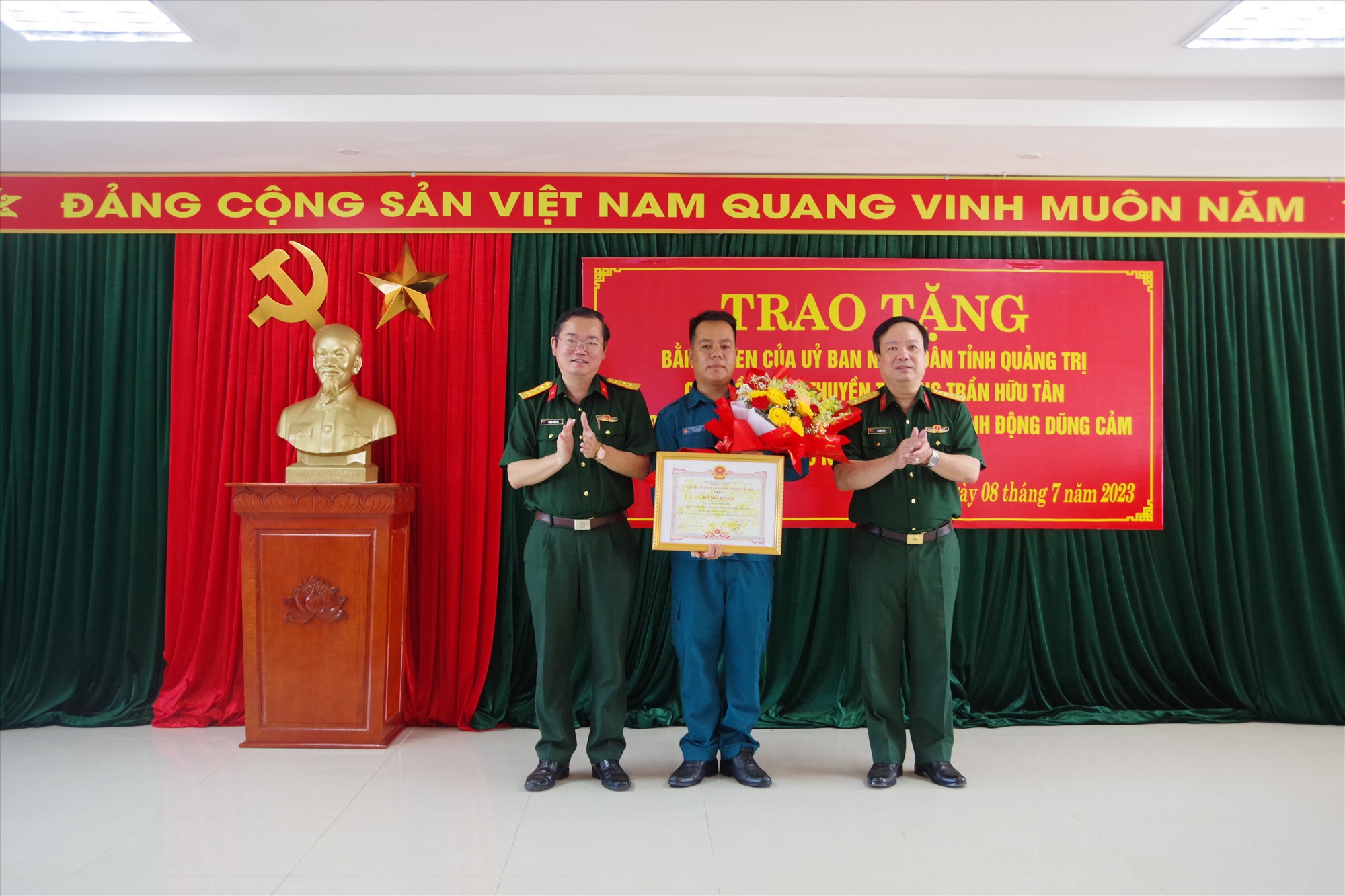 Đại tá Lê Hồng Việt, Phó Chính ủy Bộ CHQS tỉnh trao Bằng khen của Chủ tịch UBND tỉnh cho Thuyền trưởng Trần Hữu Tân - Ảnh: XD