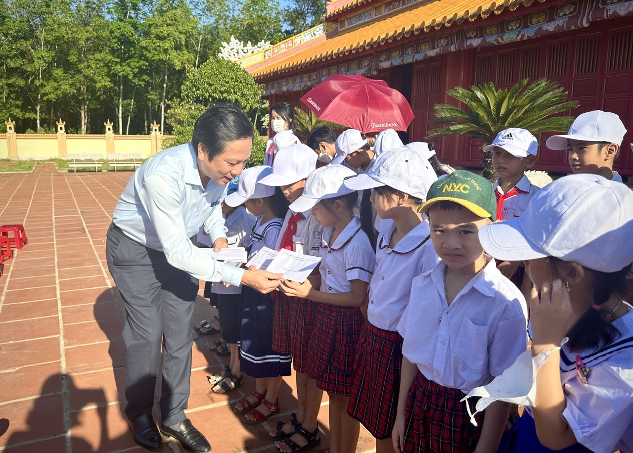 Phó Chủ tịch UBND tỉnh Hoàng Nam trao quà cho các em học sinh - Ảnh: A.V
