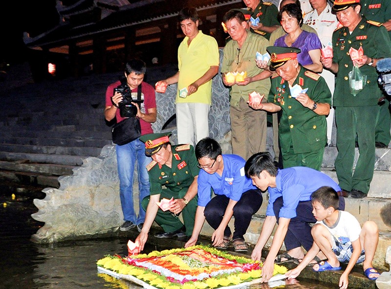 Đoàn viên, thanh niên thị xã Quảng Trị hỗ trợ các cựu chiến binh thả hoa trên sông Thạch Hãn -Ảnh: T.L