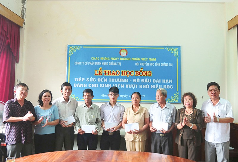 Ông Lê Đình Sung (ngoài cùng bên phải) cùng với Hội Khuyến học tỉnh trong một lần trao học bổng đỡ đầu dài hạn cho sinh viên và đại diện gia đình các sinh viên nghèo hiếu học - Ảnh: N.B