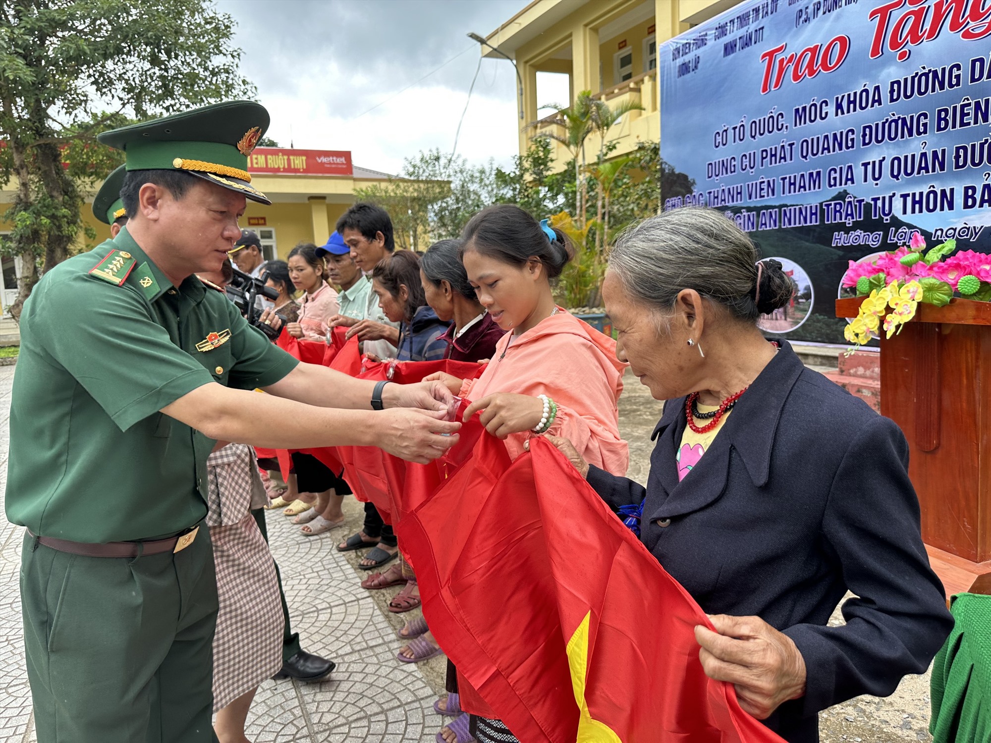 Đại tá Đinh Xuân Hùng, Chính ủy BĐBP Quảng Trị trao tặng cờ Tổ quốc và móc khóa đường dây nóng của Đồn Biên phòng Hướng Lập cho người dân.