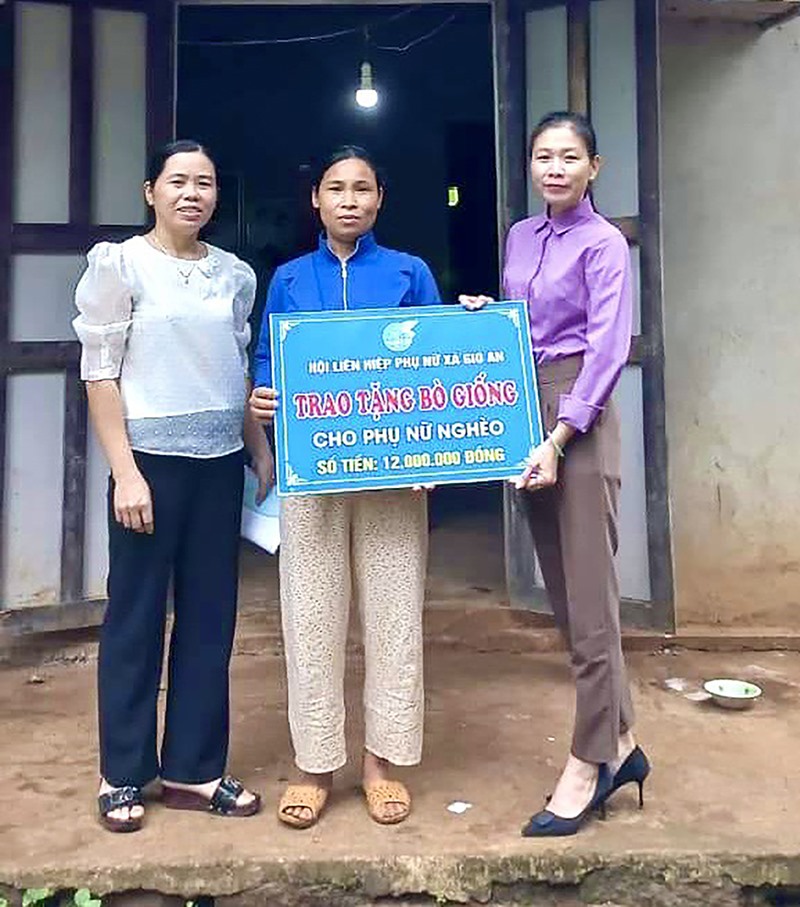 Chủ tịch Hội LHPN xã Gio An Trần Thị Thu Sương (ngoài cùng bên phải) trao biển tượng trung hỗ trợ bò giống cho phụ nữ nghèo -Ảnh: H.N