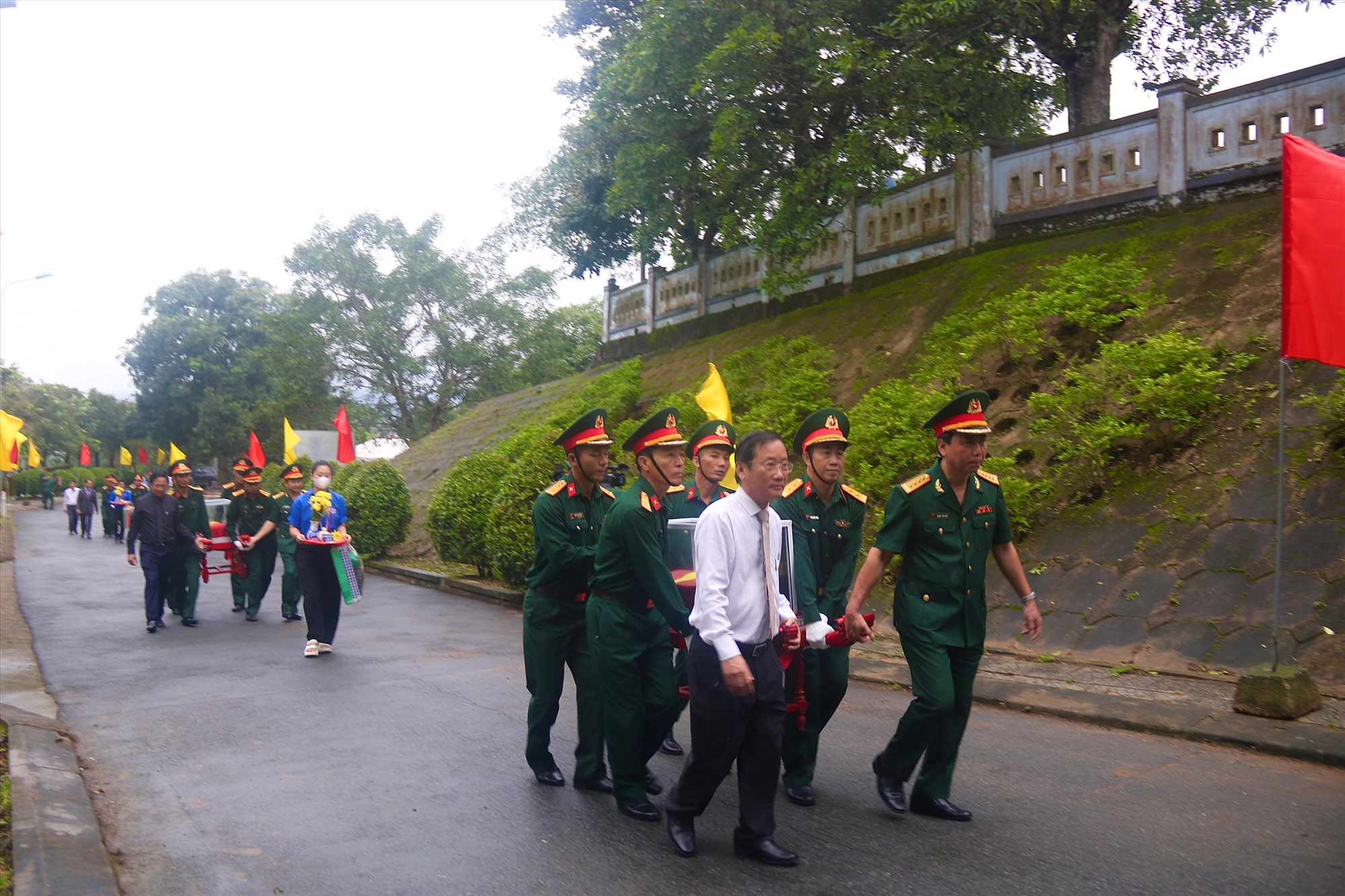 Các đại biểu cùng cán bộ, chiến sĩ lực lượng vũ trang đưa hài cốt liệt sĩ đến nơi an táng - Ảnh: N.B