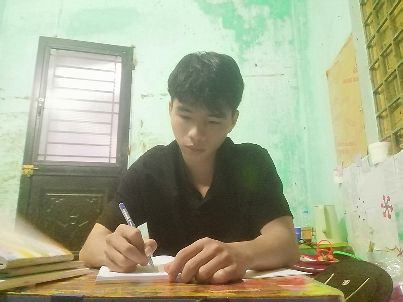 Trương Văn Tiến tranh thủ học bài sau những giờ làm thêm - Ảnh: NVCC