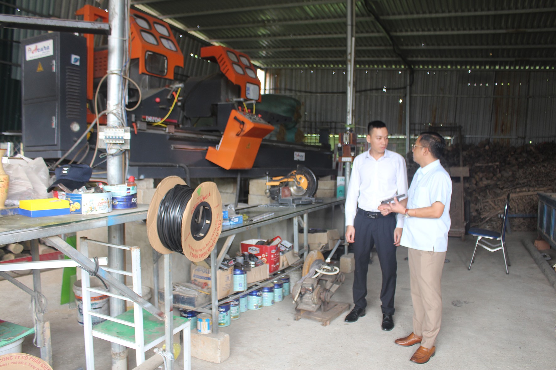 Anh Văn Đình Dũng (bên trái) được thụ hưởng nguồn kinh phí chương trình khuyến công thị xã Quảng Trị để đầu tư hệ thống máy cắt nhôm CNC cao cấp, giúp tự động hóa quá trình sản xuất -Ảnh: H.T