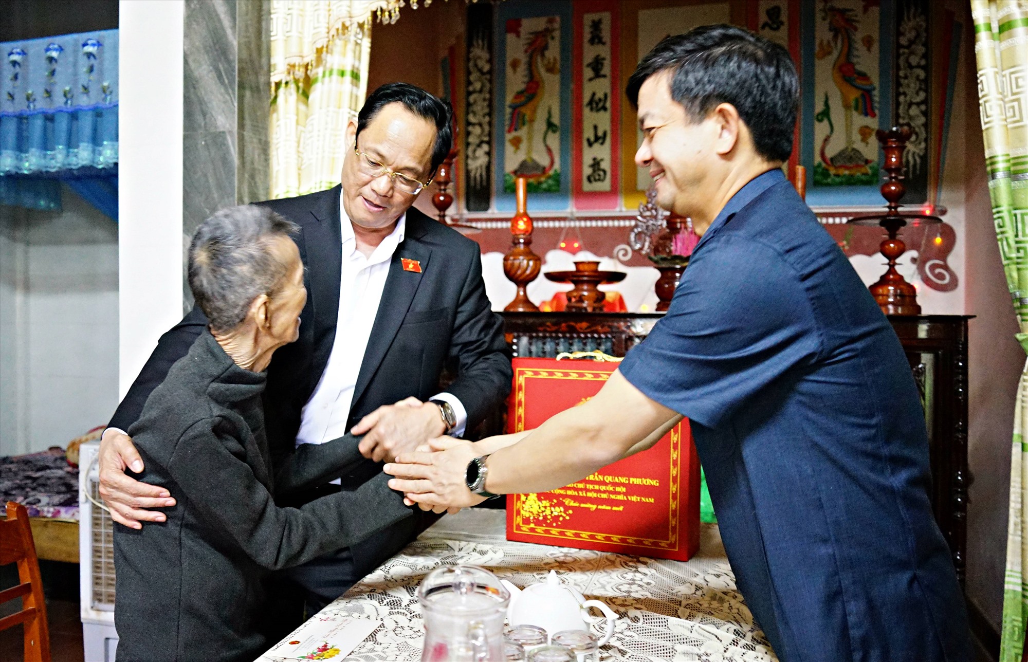 Phó Chủ tịch Quốc hội Trần Quang Phương và Bí thư Tỉnh ủy Lê Quang Tùng thăm hỏi, tặng quà cho ông Nguyễn Ngọc Thành, 95 tuổi, thương binh hạng 3/4 ở xã Cam Chính - Ảnh: L.A
