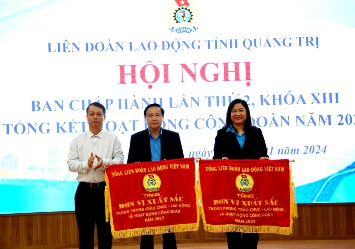 Phó Chủ tịch HĐND tỉnh Nguyễn Trần Huy tặng Cờ thi đua của Tổng LĐLĐ Việt Nam cho 2 tập thể - Ảnh: L.N