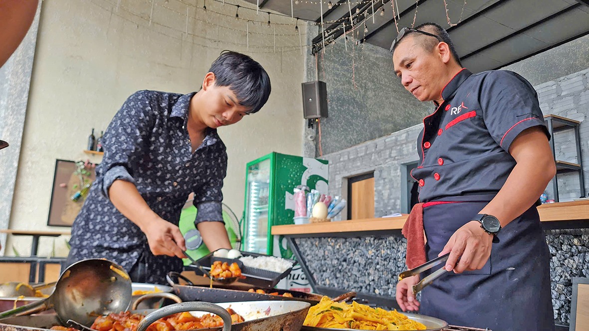 Anh Nguyễn Văn Tùng (bên phải) và Mai Vĩnh Tuấn chuẩn bị các suất ăn miễn phí cho người lao động nghèo - Ảnh: T.P