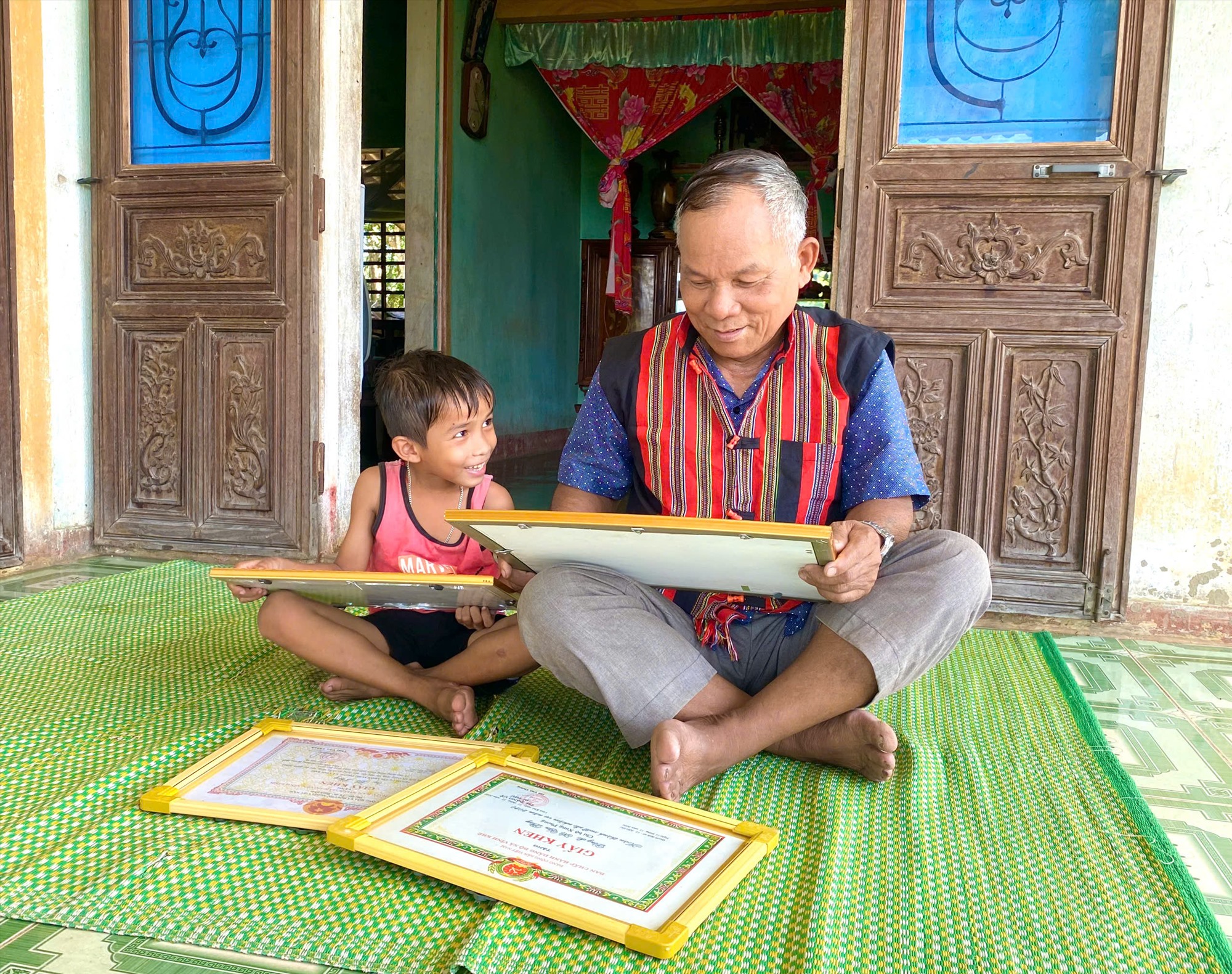 Ông Hồ Phay luôn cập nhật thông tin của Đảng, Nhà nước để làm tốt vai trò là người có uy tín trong đồng bào dân tộc thiểu số ở thôn Xung Phong - Ảnh: H.N