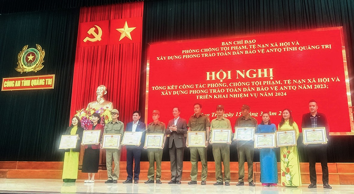 Chị Nguyễn Thị Ty (thứ 3 từ phải qua) nhận bằng khen của Chủ tịch UBND tỉnh Quảng Trị do có thành tích xuất sắc trong phong trào “Toàn dân bảo vệ an ninh Tổ quốc” năm 2023 - Ảnh: NVCC