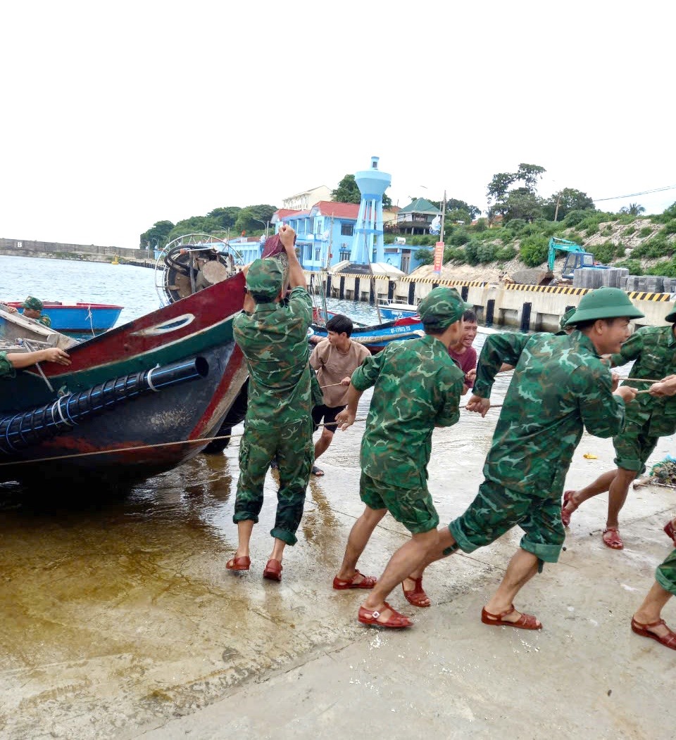 Lực lượng vũ trang huyện đảo Cồn Cỏ giúp ngư dân đưa tàu thuyền từ âu cảng lên cao tránh bão - Ảnh: HĐCC