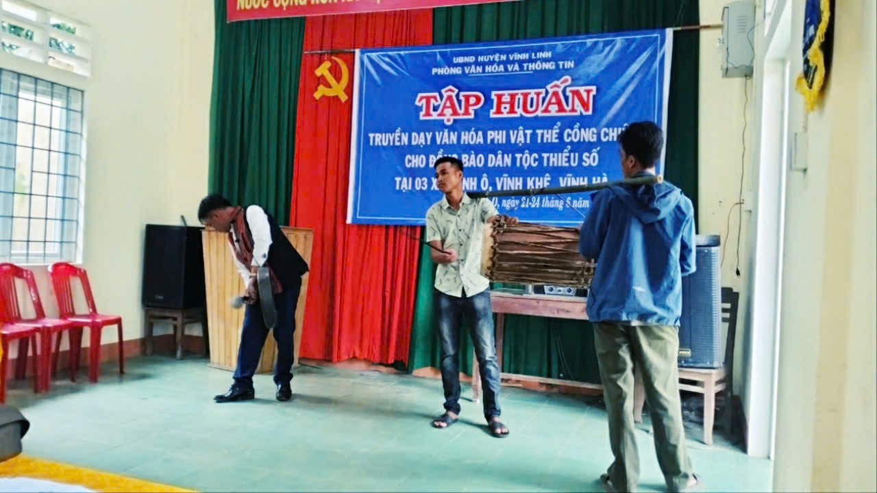 Thầy giáo Hồ Văn Hoàn (người đánh chiêng) hướng dẫn cách đánh theo điệu lễ mừng lúa mới- Ảnh N.Đ.T