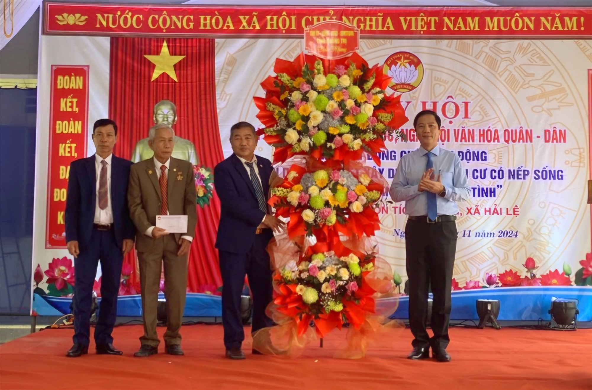 Phó Chủ tịch UBND tỉnh Hoàng Nam tặng hoa, quà chúc mừng Ngày hội Đại đoàn kết dân tộc và Ngày hội văn hóa quân - dân ở thôn Tích Tường - Ảnh: K.S