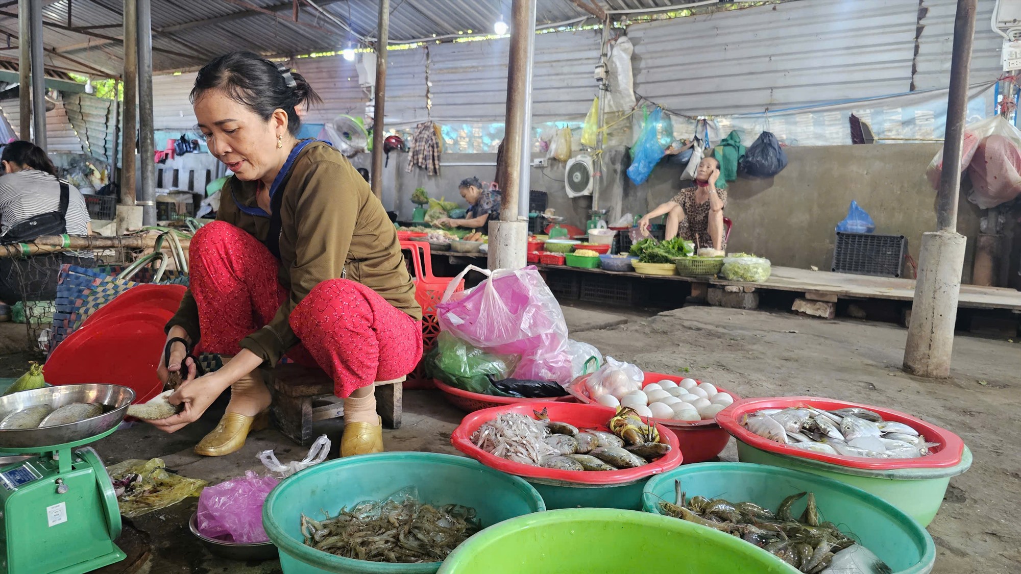 Bà Liên nhanh tay làm sạch cá cho khách - Ảnh: T.P