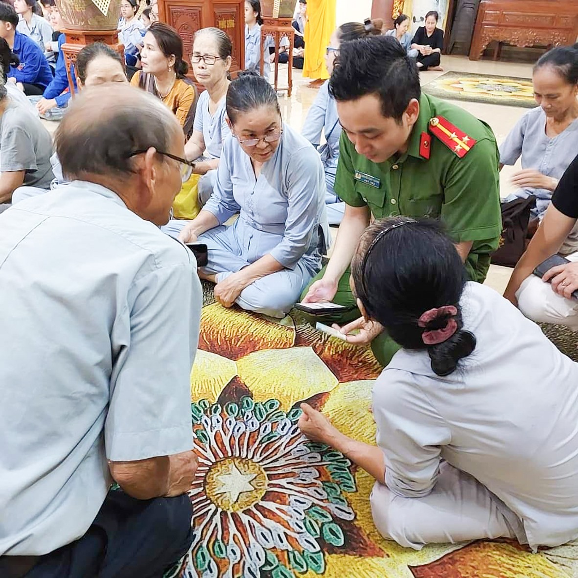 Cán bộ, chiến sĩ Công an TP. Đông Hà tuyên truyền, hướng dẫn bà con phật tử kích hoạt tài khoản định danh điện tử VneID - Ảnh: S.H