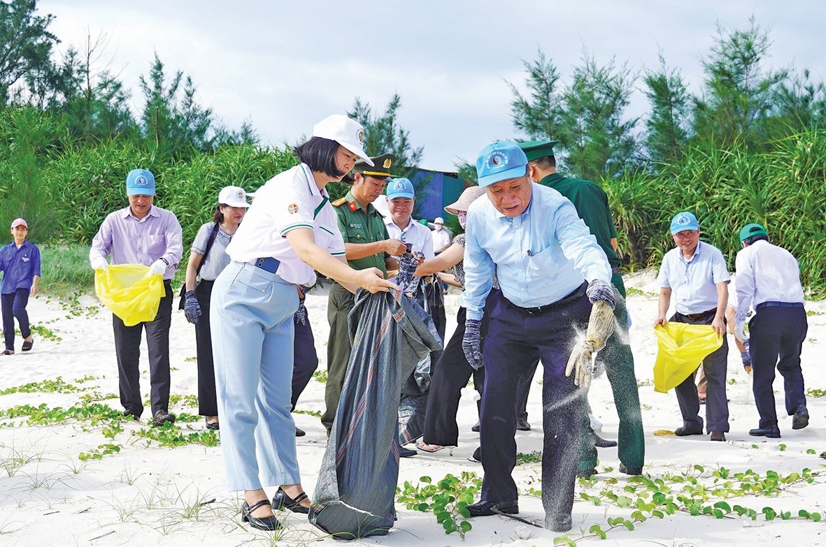 Các đại biểu và người dân chung tay làm sạch bãi biển xã Vĩnh Thái tại Lễ mít tinh hưởng ứng Tuần lễ Biển và Hải đảo Việt Nam năm 2024 -Ảnh: S.H