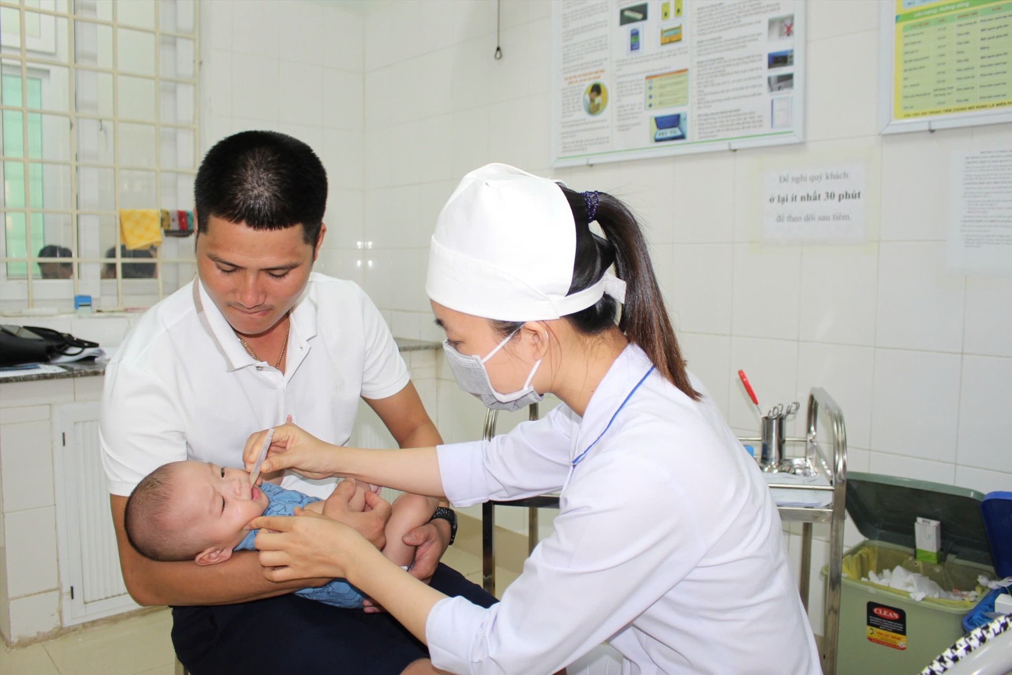 Cho trẻ uống vaccine phòng bệnh. Ảnh: BỘI NHIÊN