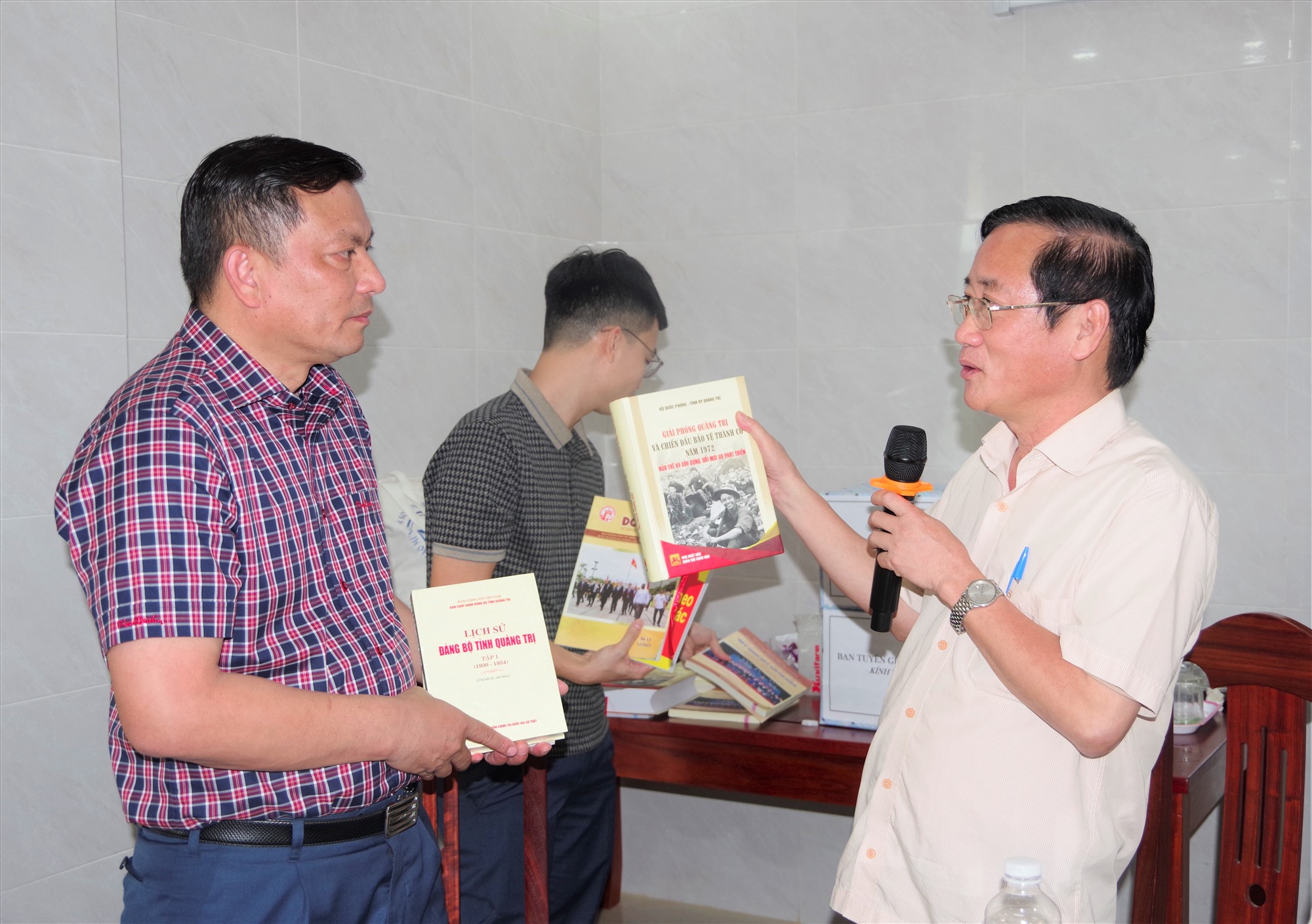 Đồng chí Hồ Đại Nam -UVBTV, Trưởng Ban Tuyên giáo Tỉnh ủy đang giới thiệu và trao tặng Lịch sử Đảng bộ tỉnh Quảng Trị và những tài liệu tuyên truyền