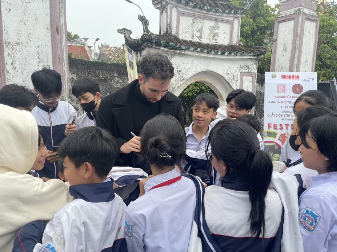 Các em học sinh ở Vân Cù xin chữ ký của tiktoker nổi tiếng người Pháp đến Vân Cù dự sự kiện