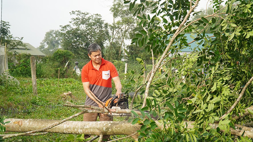 Anh Hoàng Văn Bình cắt cây để hiến đất cho thôn xây dựng khu vui chơi giải trí -Ảnh: ANH VŨ