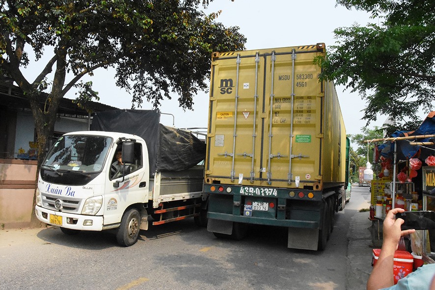 Xe container chen chúc chạy qua đoạn đường nhỏ hẹp, đông dân cư ở địa bàn thôn Dương Lệ Đông, xã Triệu Thuận, huyện Triệu Phong - Ảnh: Đ.V