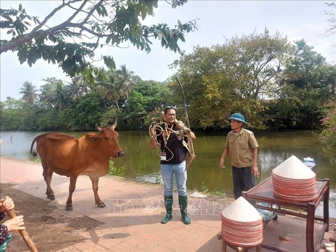 Khách quốc tế hào hứng tham gia trải nghiệm “Một ngày làm nông dân” tại Làng cổ Đường Lâm. Ảnh: TTXVN phát