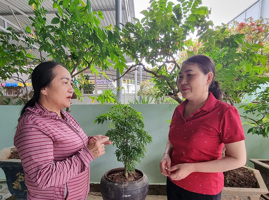 Bà Bùi Thị Hồng (bên phải) trao đổi với Tổ trưởng tổ tiết kiệm và vay vốn của Khu phố 5, thị trấn Cửa Việt, huyện Gio Linh về hiệu quả sử dụng vốn vay -Ảnh: TÚ LINH