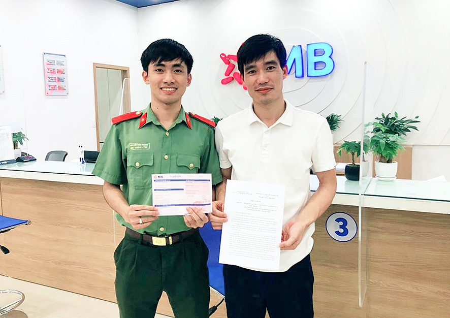 Em Nguyễn Văn Trọng (bên trái) trả lại số tiền cho người chuyển khoản nhầm - Ảnh: T.L