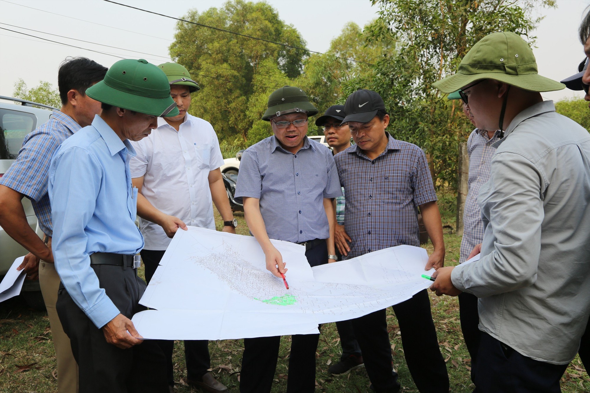 Phó Chủ tịch UBND tỉnh Lê Đức Tiến kiểm tra hiện trạng và trên bản đồ khu đất có 21 hộ dân đang sinh sống tại xã Gio Mai, huyện Gio Linh thuộc diện phải tái định cư - Ảnh: Lê Minh