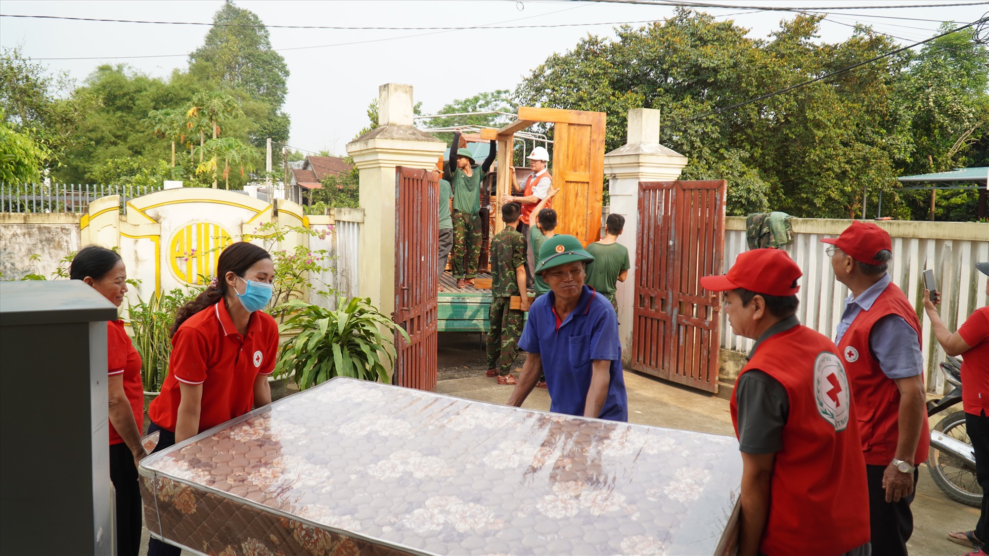 Lực lượng hội viên Chữ thập đỏ và bộ đội giúp người dân di dời tài sản đến khu tái định cư ở Cam Hiếu-Ảnh: Anh Vũ