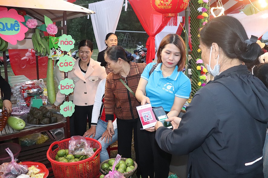 Thông qua phiên chợ quê không dùng tiền mặt do Hội LHPN xã Cam Thủy, huyện Cam Lộ tổ chức, nhiều hội viên hiểu rõ hơn tiện ích của việc thanh toán không dùng tiền mặt - Ảnh: T.P