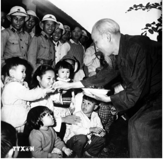 Chủ tịch Hồ Chí Minh thăm nhà trẻ, chia kẹo cho thiếu nhi là con cháu của công nhân Xí nghiệp gốm Dụ Phong và Hợp tác xã Nông nghiệp Soáy Ngườn, thị xã Móng Cái (nay là Thành phố Móng Cái, tỉnh Quảng Ninh). (Ảnh: TTXVN)