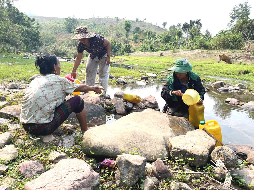 Người dân thôn A Rông, xã Lìa, huyện Hướng Hóa lấy nước từ con suối đang khô cạn về để sinh hoạt, ăn uống - Ảnh: Đ.V