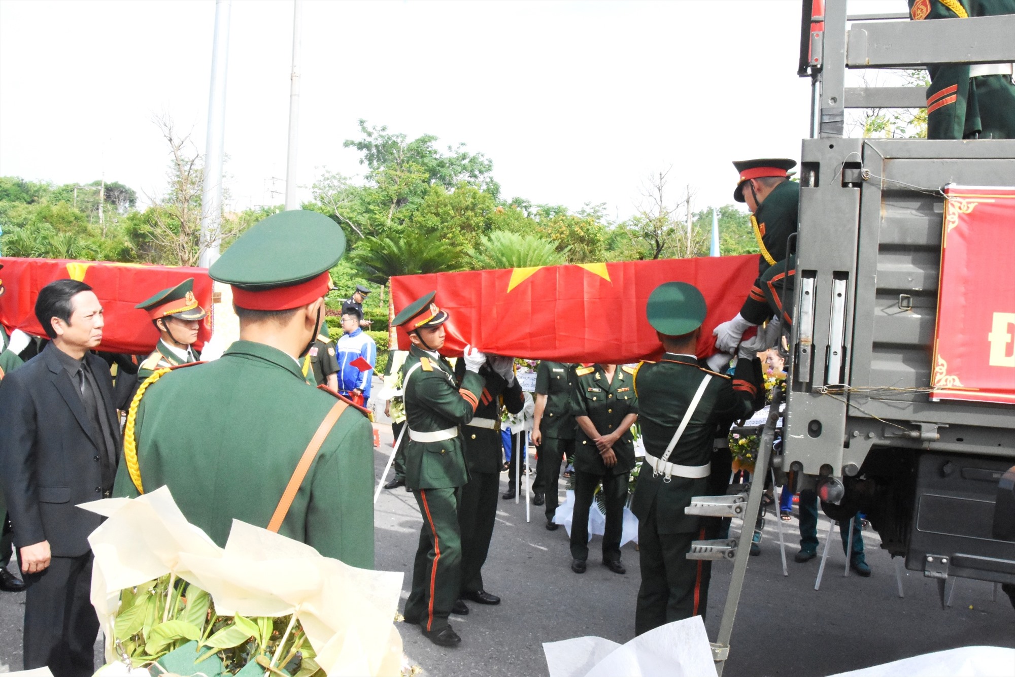 Đưa các hài cốt liệt sĩ lên xe chuẩn bị di chuyển về Nghĩa trang liệt sĩ quốc gia Đường 9- Ảnh: ĐV