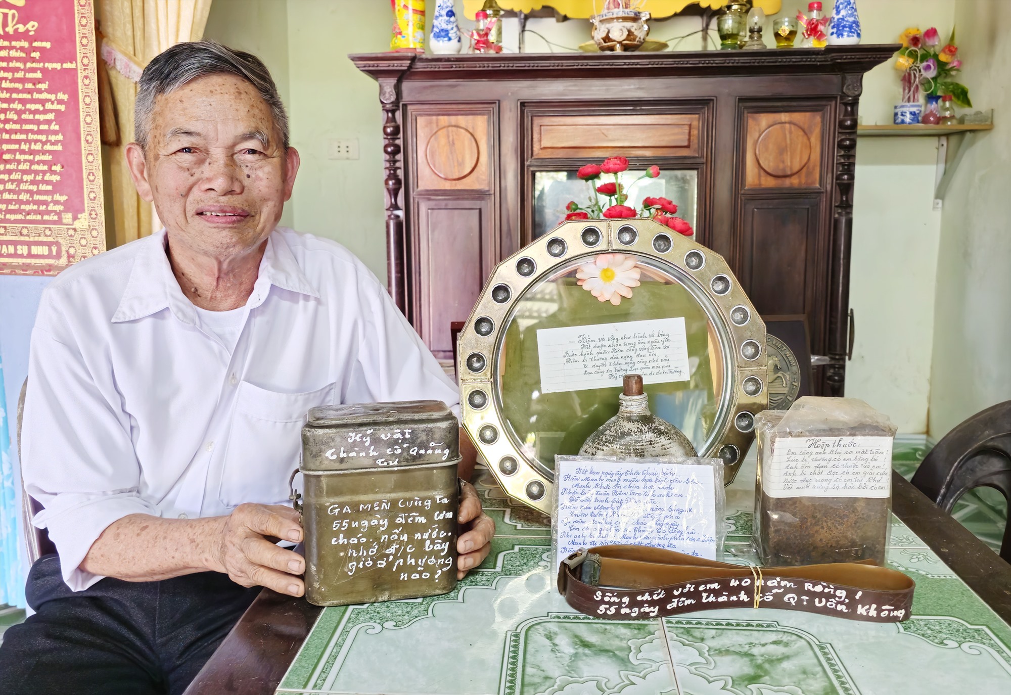 Ông Hoàng Văn Kiệm bên các kỷ vật chiến tranh mà ông nâng niu hằng ngày -Ảnh: TÚ LINH