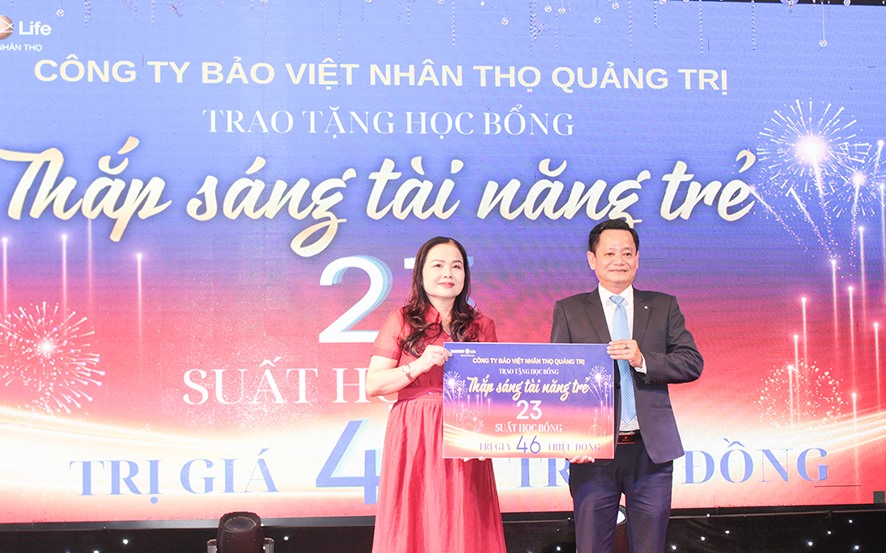 Giám đốc Sở Giáo dục và Đào tạo Quảng Trị Lê Thị Hương nhận biển tượng trưng 23 suất học bổng dành cho học sinh giỏi từ Công ty Bảo Việt Nhân thọ Quảng Trị - Ảnh: BẢO BÌNH