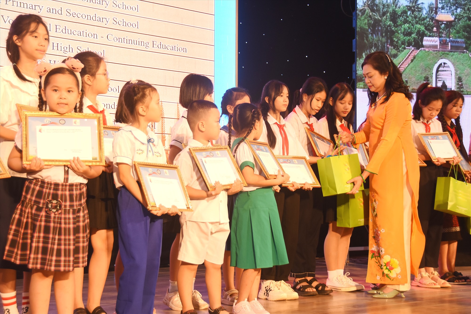 Bà Phùng Thị Thu Thủy, Chủ nhiệm Câu lạc bộ Di sản Áo Dài Việt Nam - TP. Hồ Chí Minh trao quà cho các em học sinh đoạt giải cuộc thi vẽ tranh - Ảnh: ĐV