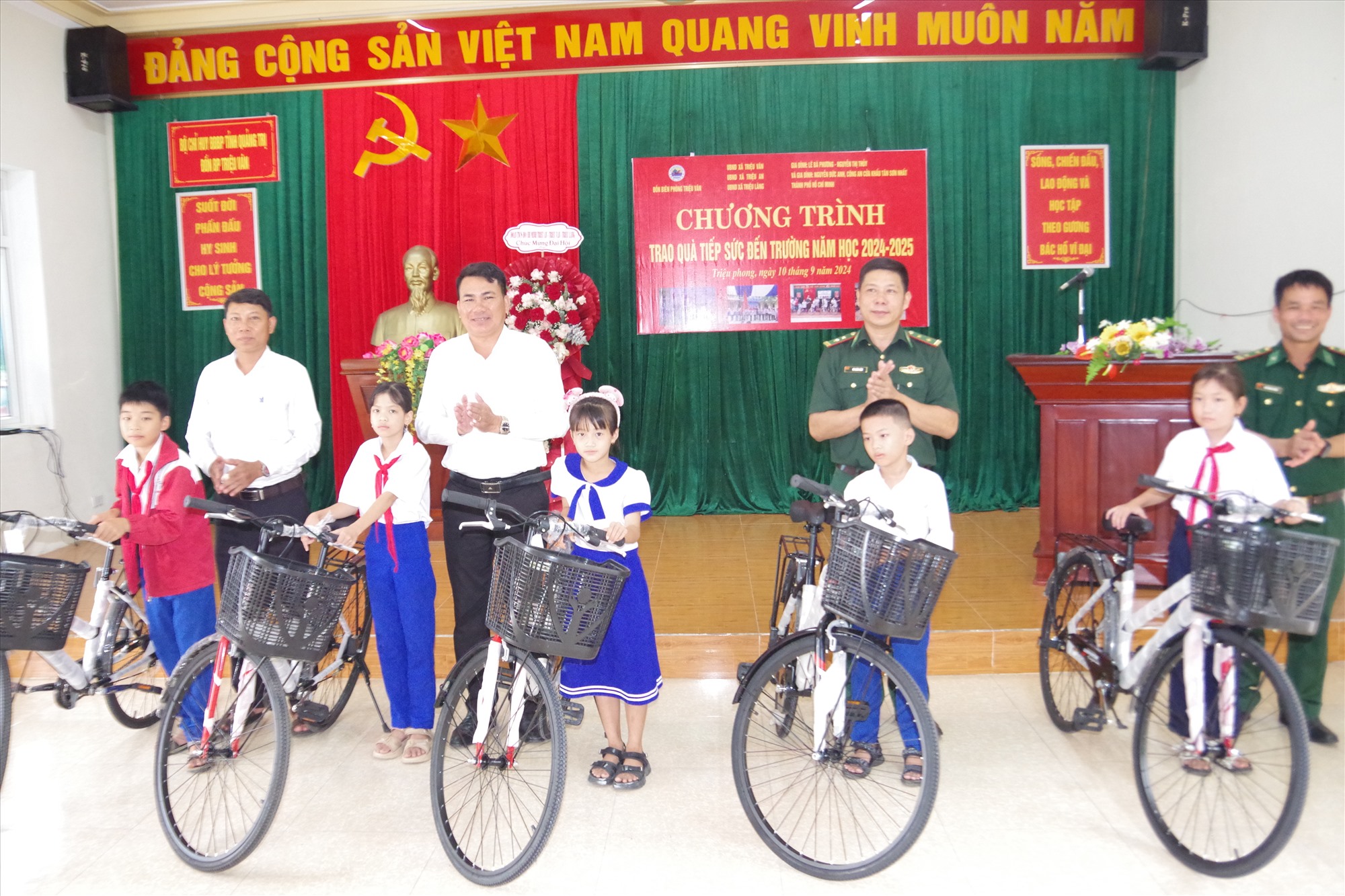 Trung tá Võ Xuân Lâm - Phó CNCT Bộ đội Biên phòng tỉnh và Lãnh đạo xã Triệu Vân trao quà cho các cháu học sinh nghèo học giỏi