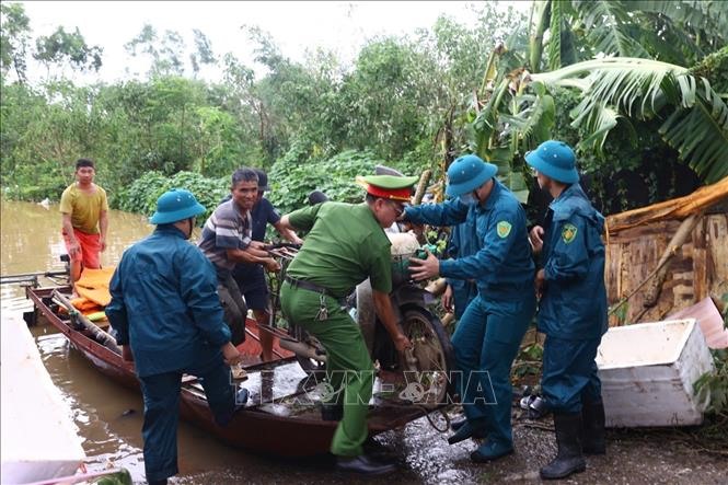 Lực lượng dân quân tự vệ và công an phường Yên Phụ hỗ trợ nhân dân đi chuyển tài sản khỏi vùng ngập. Ảnh: Huy Hùng/TTXVN