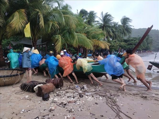 Cán bộ, chiến sĩ Đồn biên phòng Cửa Đại (Hội An) giúp ngư dân đưa phương tiện loại nhỏ đến nơi trú tránh an toàn, ngày 18/9/2024. Ảnh: Đoàn Hữu Trung/TTXVN