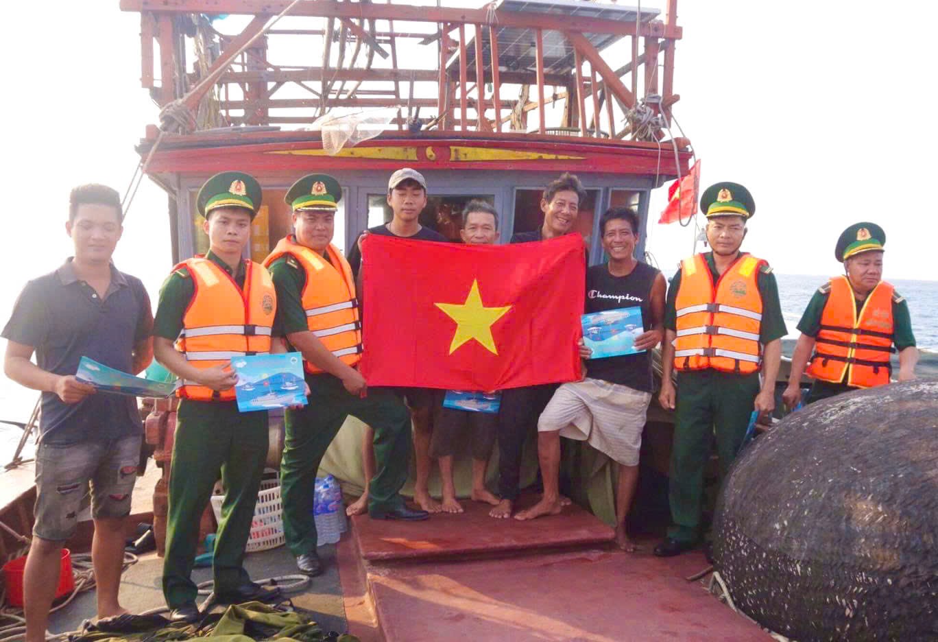 Trung úy Phan Đào Duy Nhất (thứ 2, từ trái sang) cùng cán bộ, chiến sĩ Đồn Biên phòng Cồn Cỏ tuyên truyền cho ngư dân bảo vệ biển đảo - Ảnh: NVCC