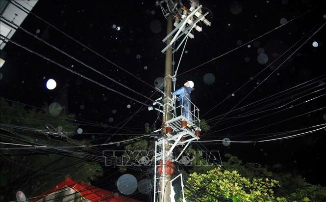 Công nhân điện lực khẩn trương khắc phục sự cố ngay trong đêm nhằm đảm bảo sinh hoạt cho nhân dân (Nam Định). Ảnh: Thái Thuần/TTXVN