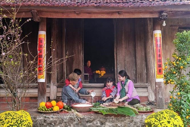 Các thành viên trong gia đình cùng nhau gói bánh chưng - một loại bánh truyền thống không thể thiếu trong dịp Tết đến Xuân về.