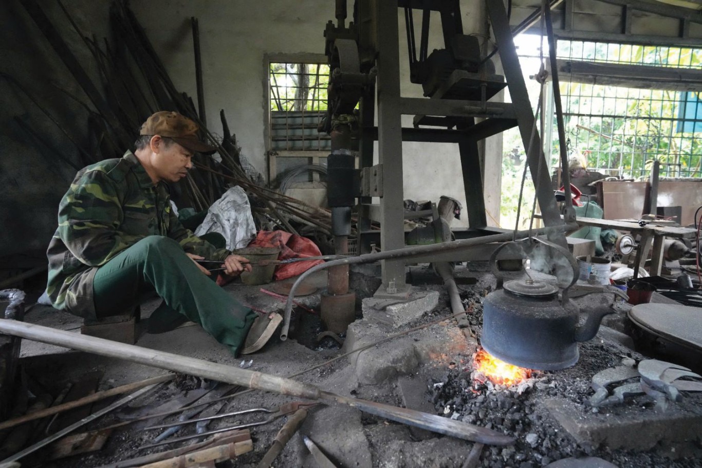 Máy đóng búa được hỗ trợ từ chế độ chính sách của tỉnh nhà đã giúp ông Nguyễn Văn Lộc tiếp tục giữ lửa lò rèn - Ảnh: H.T.T
