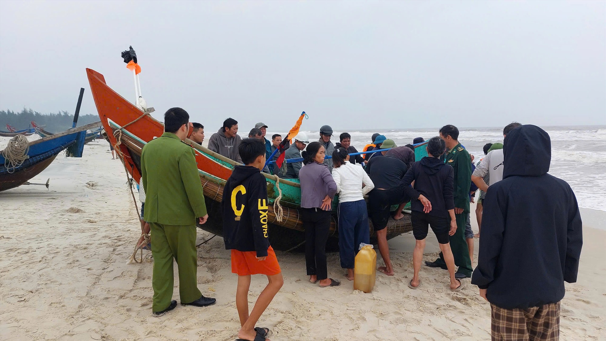 Các thuyền viên và người dân vui mừng khi được hỗ trợ đưa thuyền vào bờ. Ảnh: Đình Tiến
