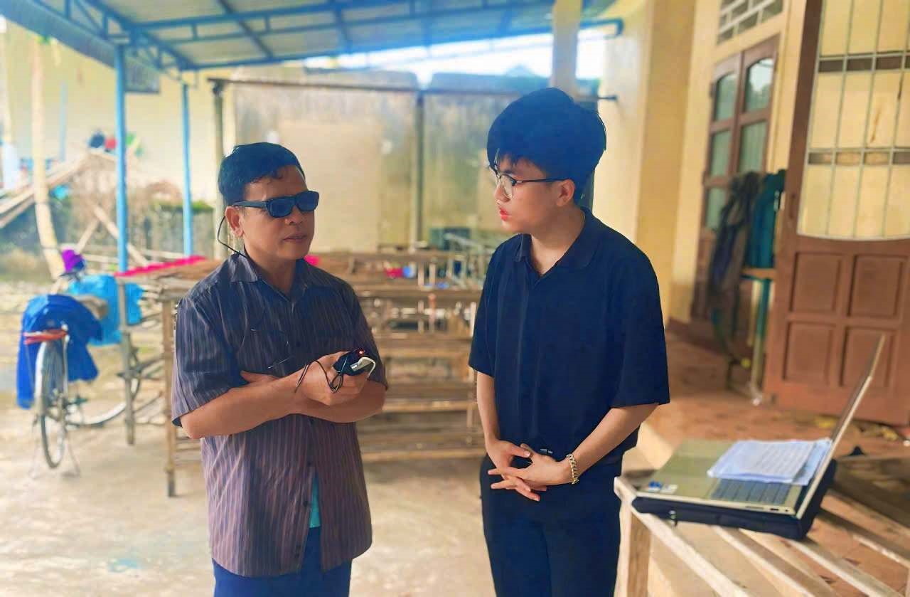 Dũng lắng nghe ý kiến phản hồi của một người khiếm thị ở huyện Hải Lăng về chiếc kính do mình sáng tạo ra - Ảnh: Q.H